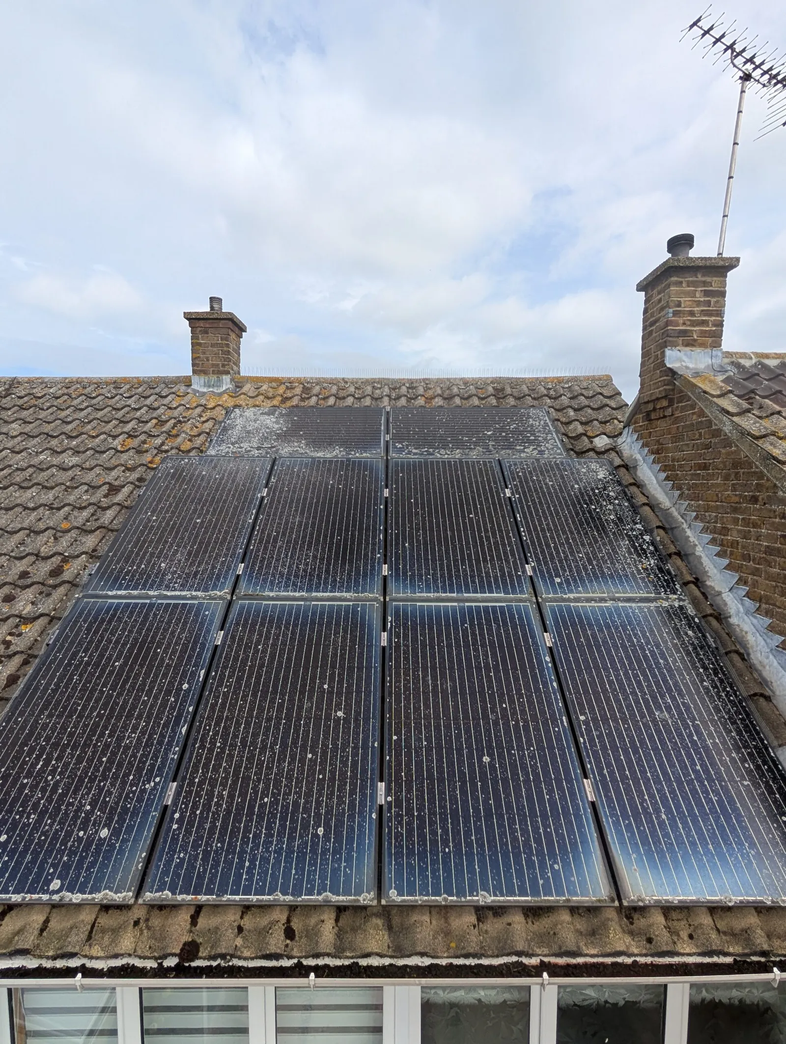 Rooftop solar array soiled with dirt and bird droppings before cleaning