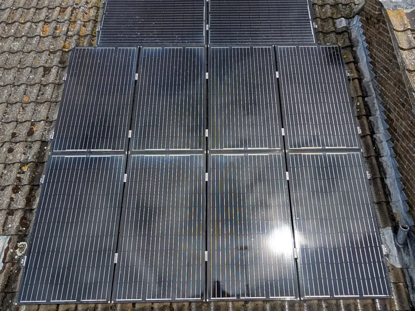 The same rooftop solar array after cleaning, photographed from the same side of the roof